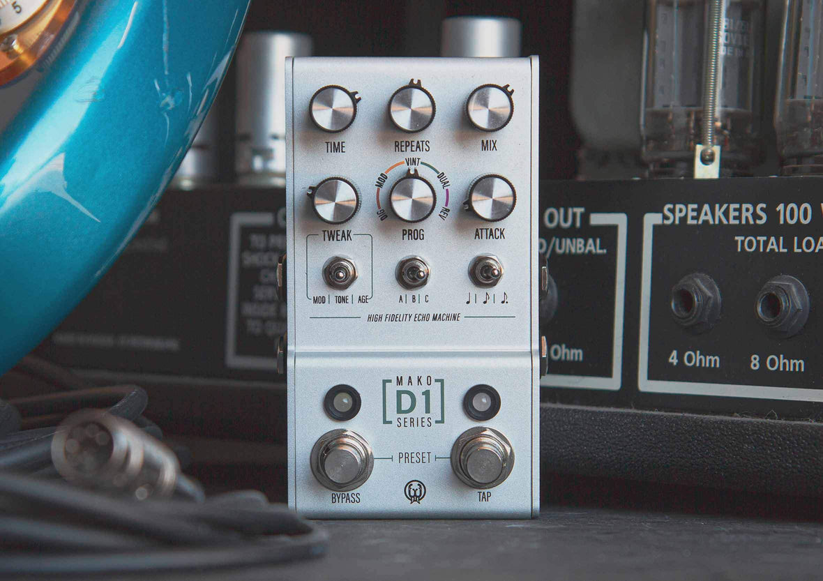 D1 Stereo Delay pedal sitting next to a guitar and amp